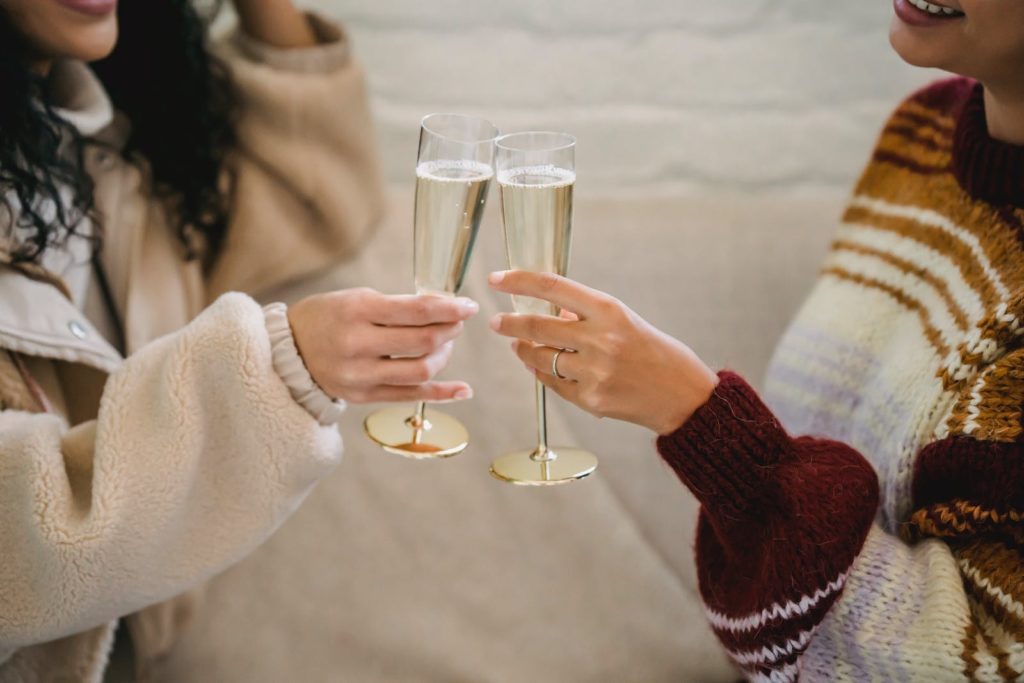 Women clinking glasses with champagne in room